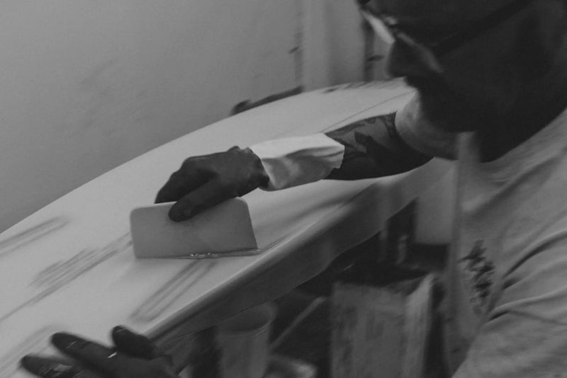 Glassing a surfboard on the production floor at PureGlass, Costa Mesa