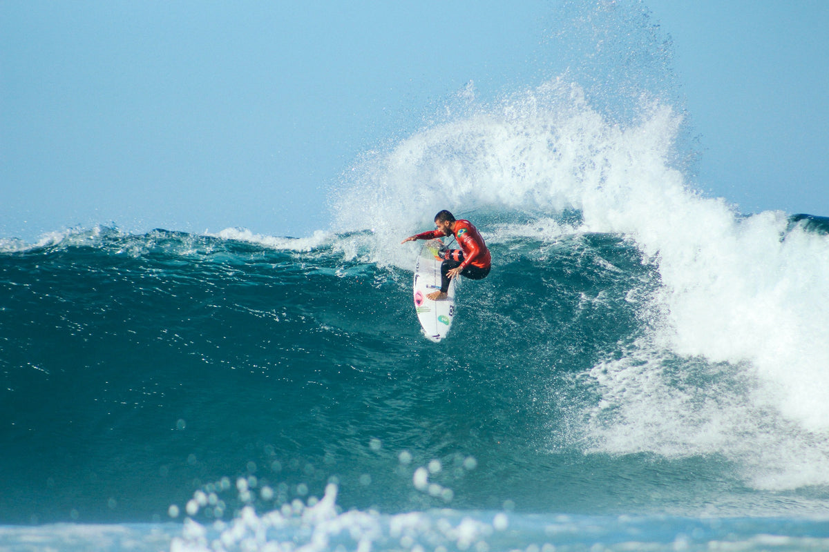 Surfer carving a wave with spray